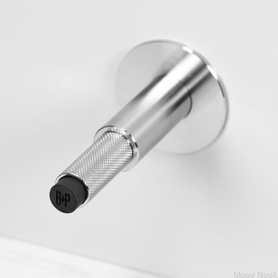 Väggmonterad dörrstoppare i silverfärgat stål med kors